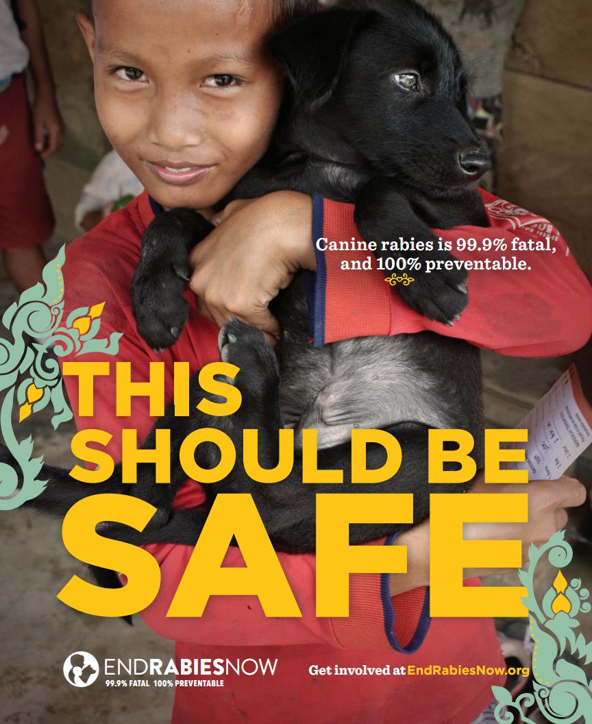 Boy holding black dog. End Rabies Now: This should be safe. 